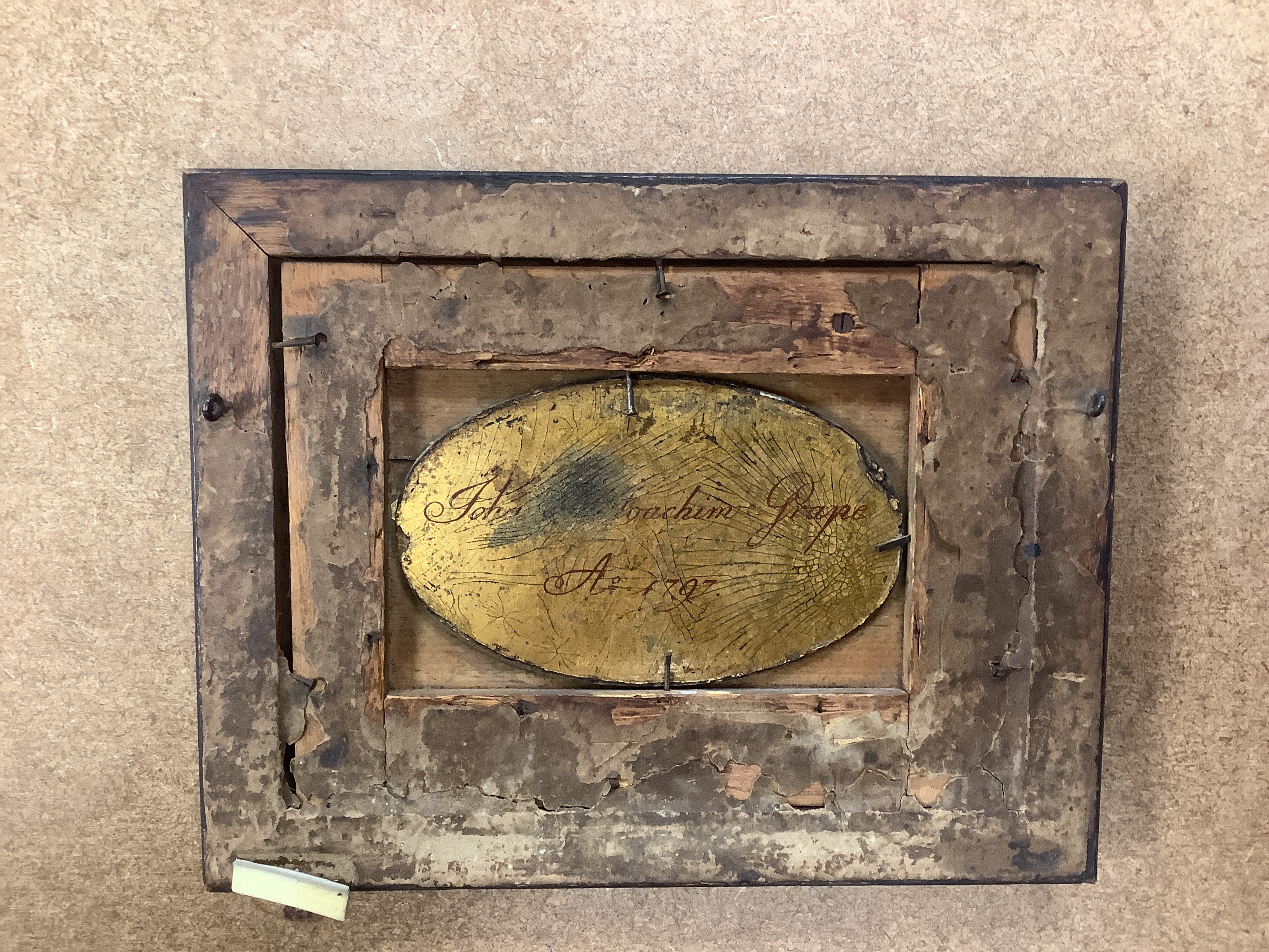 A pair of framed Sevres style porcelain oval plaques and a papier mache panel, inscribed verso and dated 1797, pair 26cm x 18cm